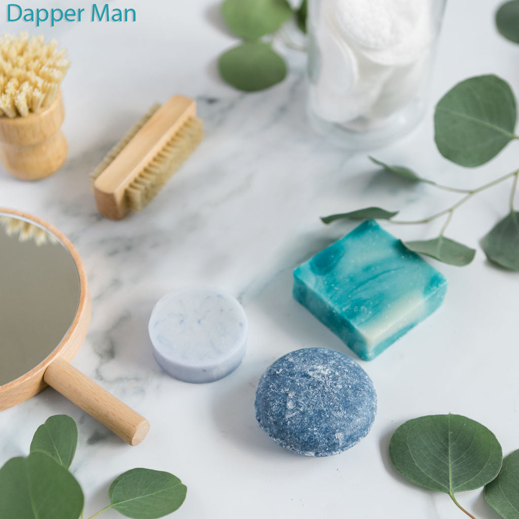An assortment of solid shampoo, conditioner, and soap bars in various colors displayed on a marble surface