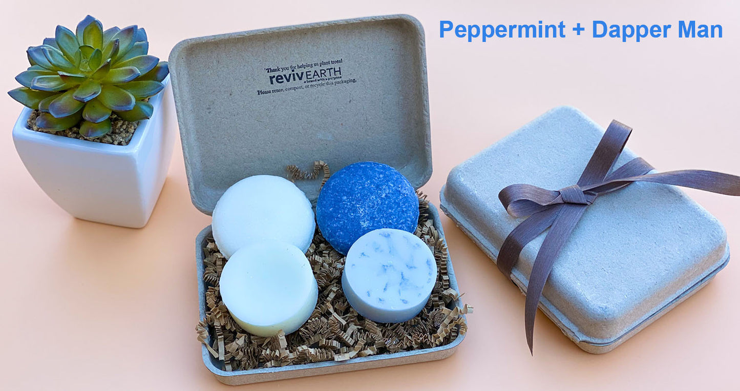 Peppermint and Argan Oil spa set gift featuring two white and two blue solid shampoo and conditioner bars in an open eco-friendly molded pulp box with a matching ribbon-tied gift box."