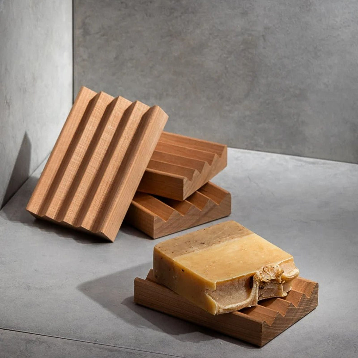 Wooden soap dish with a bar of soap on a gray surface