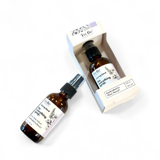 Two amber glass bottles of everything spray by revivEARTH, with one bottle inside a white branded box, displayed on a clean white background.