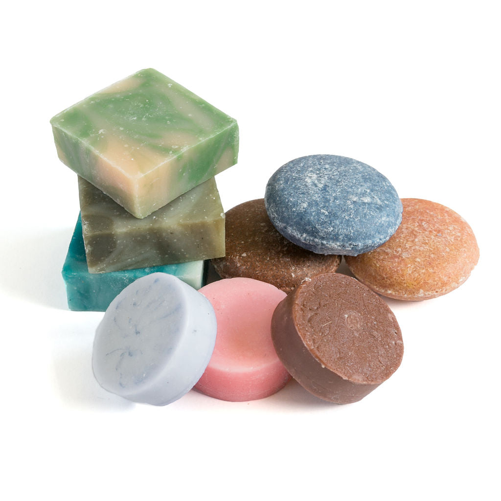 A colorful spa set gift featuring an assortment of round and square revivEARTH shampoo, conditioner, and soap bars arranged against a white background