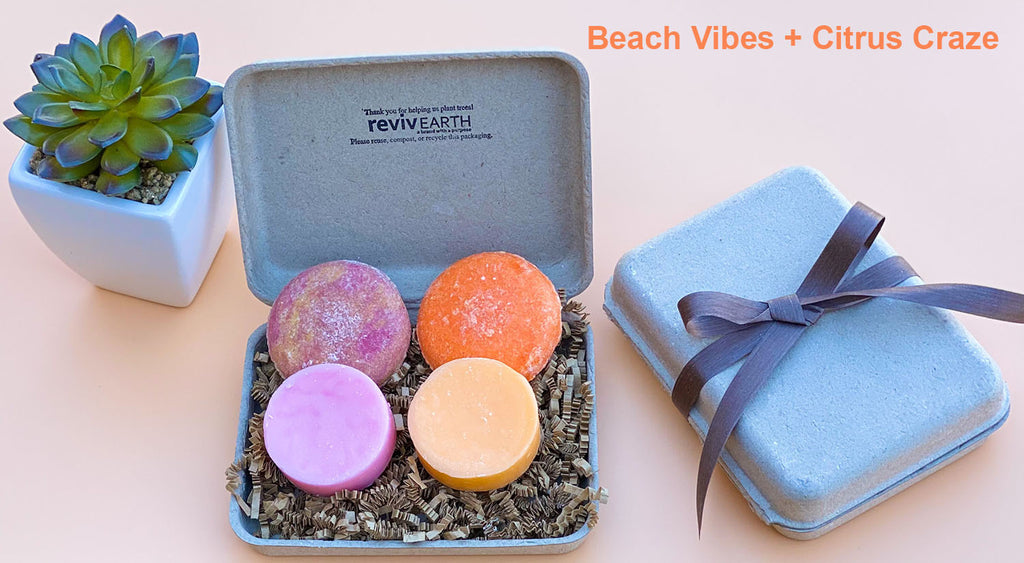 A colorful spa set gift featuring four solid shampoo and conditioner bars in pink, orange, purple, and yellow, presented in an eco-friendly molded pulp box with a decorative ribbon.
